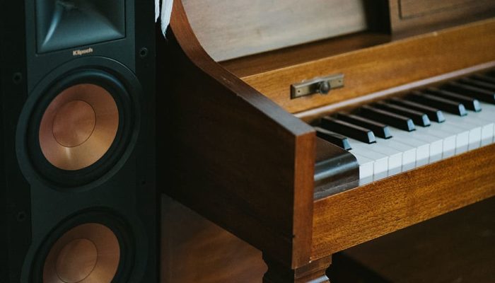 black-subwoofer-speaker-beside-brown-wooden-pianoa